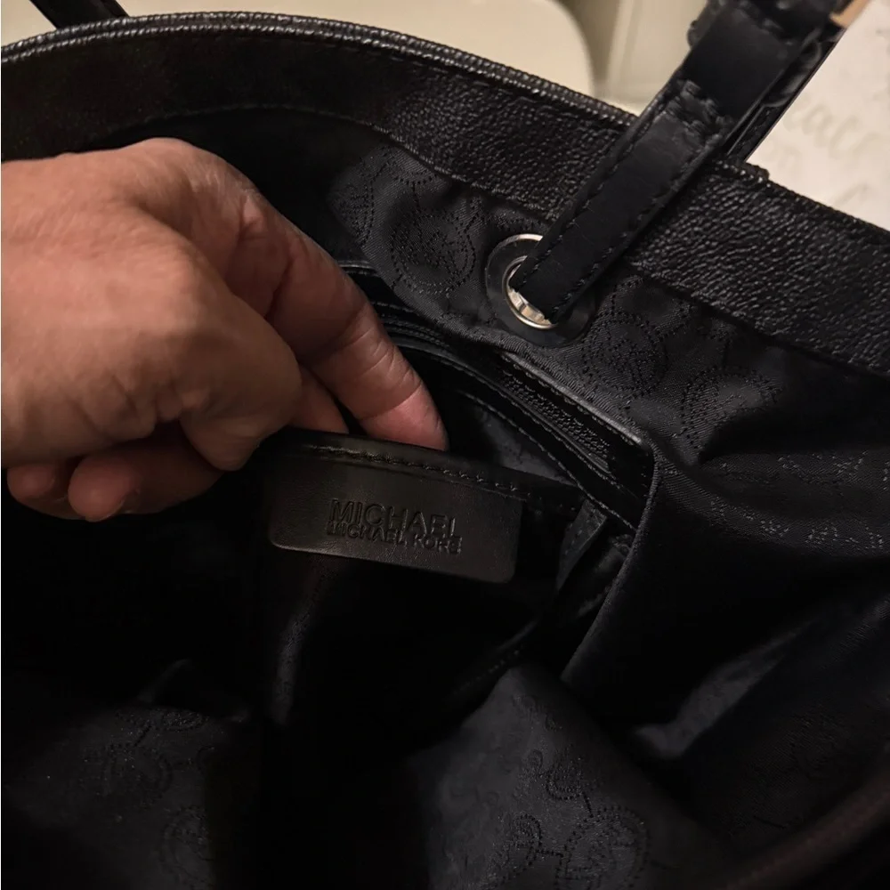 Michael Kors Elegant Black Handbag. Sides packets with a log in the front